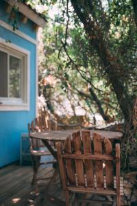 - deux chaises en bois assises autour d'une table en bois sur une terrasse dans l'établissement Blue House In The Woods- Amirim, à Amirim