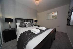 a bedroom with a large bed with two towels on it at Silver Key Apartments in Inverness