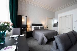 a bedroom with a bed and a couch and a table at Grosvenor Suites in Edinburgh