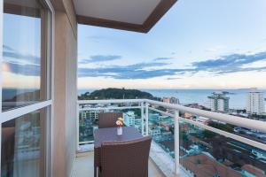 balcón con mesa y vistas al océano en Ramada by Wyndham Macae Hotel & Suites, en Macaé
