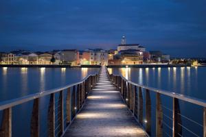 uma ponte de madeira sobre um corpo de água à noite em A.J. B&B em Lesina