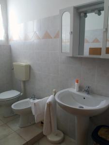 Baño blanco con lavabo y aseo en Appartamento Casteldurante en Urbania