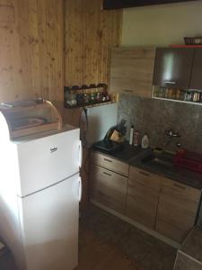 a kitchen with a white refrigerator and a sink at Vikendica na Zlatiboru in Zlatibor