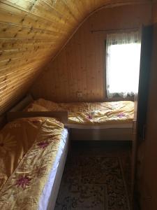 two beds in a room with a window at Vikendica na Zlatiboru in Zlatibor