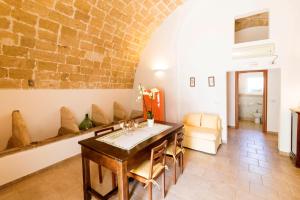 a dining room with a table and a brick wall at Masseria Carignani in Tuglie