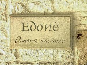 a sign on a stone wall with the words iodine dinocozonazona at Edoné in Locorotondo
