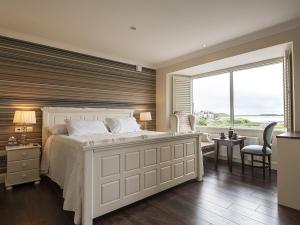 ein Schlafzimmer mit einem weißen Bett und einem großen Fenster in der Unterkunft Sea Breeze Lodge B&B Galway in Galway