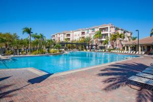 une grande piscine avec des palmiers et des bâtiments dans l'établissement Vista Cay Resort by Millenium at Universal Blvd., à Orlando
