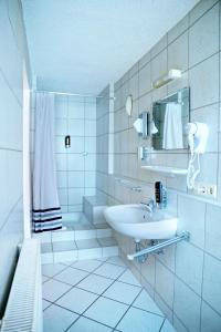 a white bathroom with a sink and a shower at La Stella in Süßen