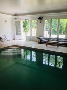 聖克勞德的住宿－Villa Ananda Huo，一间设有长椅和窗户的游泳池的客房