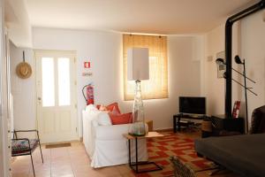 a living room with a white couch and a television at Yellow House - Checkinhome in Boliqueime