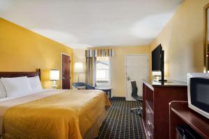 a hotel room with a bed and a flat screen tv at Travelodge by Wyndham Unadilla - Perry Near I-75 in Unadilla