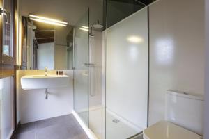 uma casa de banho com um chuveiro, um lavatório e um WC. em Cal Sadurní em Bruguera
