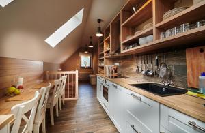 a kitchen with white cabinets and wooden floors at Sad nad Klingerom in Banská Štiavnica