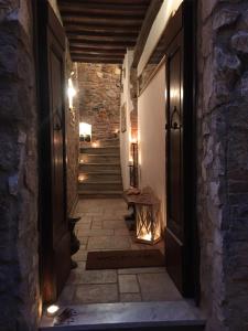 an empty hallway with a door and stairs at night at La Divina Dimora Il Castello degli Spiriti Magni in Montepescali