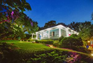 a large white house with a garden in front of it at Hotel Saint Cecilia in Austin
