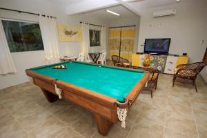 a pool table in a living room with at Igarakuê Hotel Pousada in Japaratinga