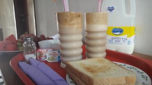 a tray with two candles and a plate with bread and milk at Marina's Rooms in Larnaca