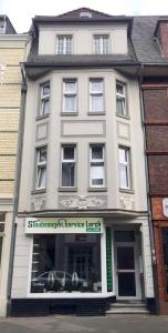 a large white building with a sign in front of it at Monterwohnungen Santos-Lerch in Viersen