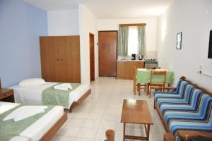una camera d'albergo con due letti e un tavolo di Maritime a Kremasti
