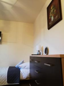 a bedroom with a bed and a dresser with a lamp at Noclegi u Mai in Olsztyn