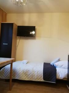 a bedroom with two beds and a tv on the wall at Noclegi u Mai in Olsztyn