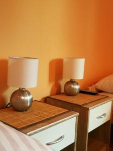 two tables with lamps on them in a bedroom at Noclegi u Mai in Olsztyn