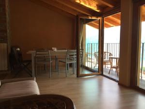 ein Wohnzimmer mit einem Tisch und Stühlen sowie einem Balkon in der Unterkunft Casa Rosa holiday in Fonteno
