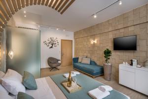 uma sala de estar com um sofá azul e uma televisão em Agave Suites em Chania Town