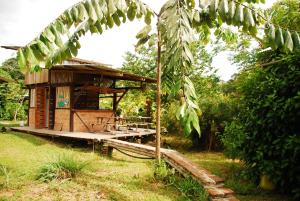 a small wooden building with a porch in a field at Maracumbo Lodge in Mompiche