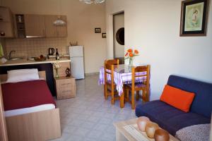 een keuken en een woonkamer met een bank en een tafel bij Palmira Apartments in Makry Gialos