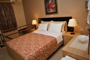 a bedroom with a large bed and two lamps at Palmira Apartments in Makry Gialos