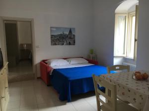 マテーラにあるAppartamento Le Tre Volteのベッドルーム(青いベッド1台、テーブル付)
