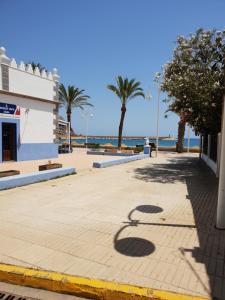 una calle con palmeras y el océano en el fondo en Jávea Golden Beach 1 Arenal Beach, en Jávea