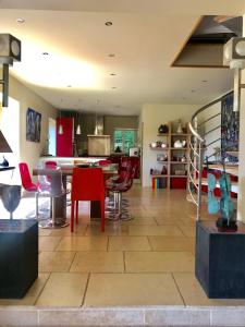 ヴィレ・シュル・メールにあるSuperbe Villa Individuelle avec Piscine et Tennis privatifsの広いキッチン(赤い椅子、テーブル付)