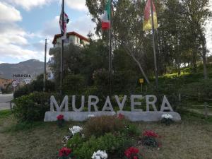 una señal que dice muravango con banderas y flores en La Casa del Cuore, en Muravera