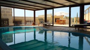 a swimming pool with a chair and a table at Casa en finca de uva con piscina privada, cubierta y climatizada in La Degollada