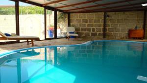 a swimming pool in a house with a chair and a table at Casa en finca de uva con piscina privada, cubierta y climatizada in La Degollada +31 photos