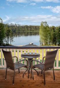 una mesa y sillas en una terraza con vistas al lago en Rantatähti Villa en Syöte