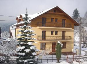 dom w śniegu z choinką świąteczną w obiekcie Rekreačný dom pod Dedovou w Oščadnicy