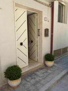 uma porta aberta com dois vasos de plantas em frente a um edifício em Luna d'Arte em Mussomeli