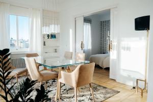 a living room with a glass table and chairs at Heima Serrano Penthouse in Madrid