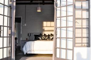 um quarto com uma cama com lençóis brancos e almofadas em Avonsrus Guesthouse em Augrabies