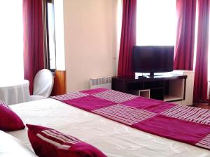 Un dormitorio con una cama con una manta morada. en Gran Hotel Ovalle, en Ovalle