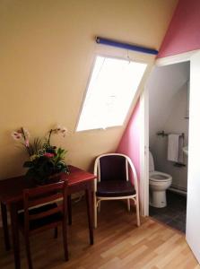 ein Bad mit einem Tisch, einem Fenster und einem WC in der Unterkunft Hôtel Du Brabant in Paris