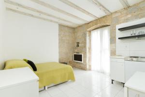 Habitación con cocina y cama con manta amarilla. en Eco B&B Old Town Beach, en Split