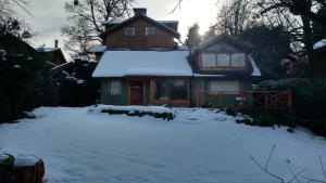 una casa con un patio cubierto de nieve delante de ella en Casa La Veleta en San Martín de los Andes