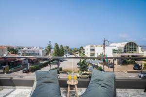 d'un balcon avec des oreillers et une vue sur la ville. dans l'établissement Sun Ray Luxury Apartments, à Agia Marina