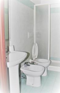 a white bathroom with a toilet and a sink at Hotel Moon Light in Rome