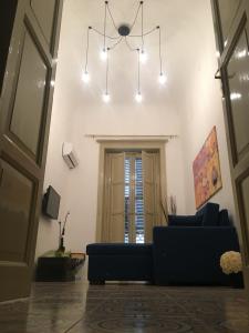 a living room with a couch and a chandelier at Gocce Siciliane Apartments in Porto Empedocle